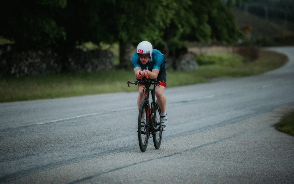 Black and white: triathlete on a time-trial bike on a country road