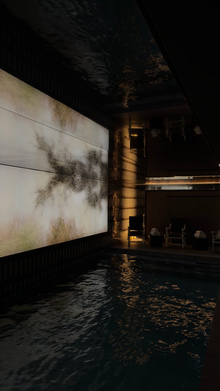 Underground pool with a lit stone wall, shot on iPhone